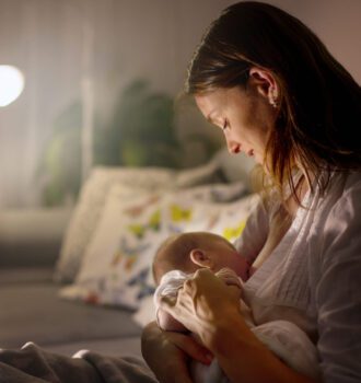 Young,Beautiful,Mother,,Breastfeeding,Her,Newborn,Baby,Boy,At,Night,